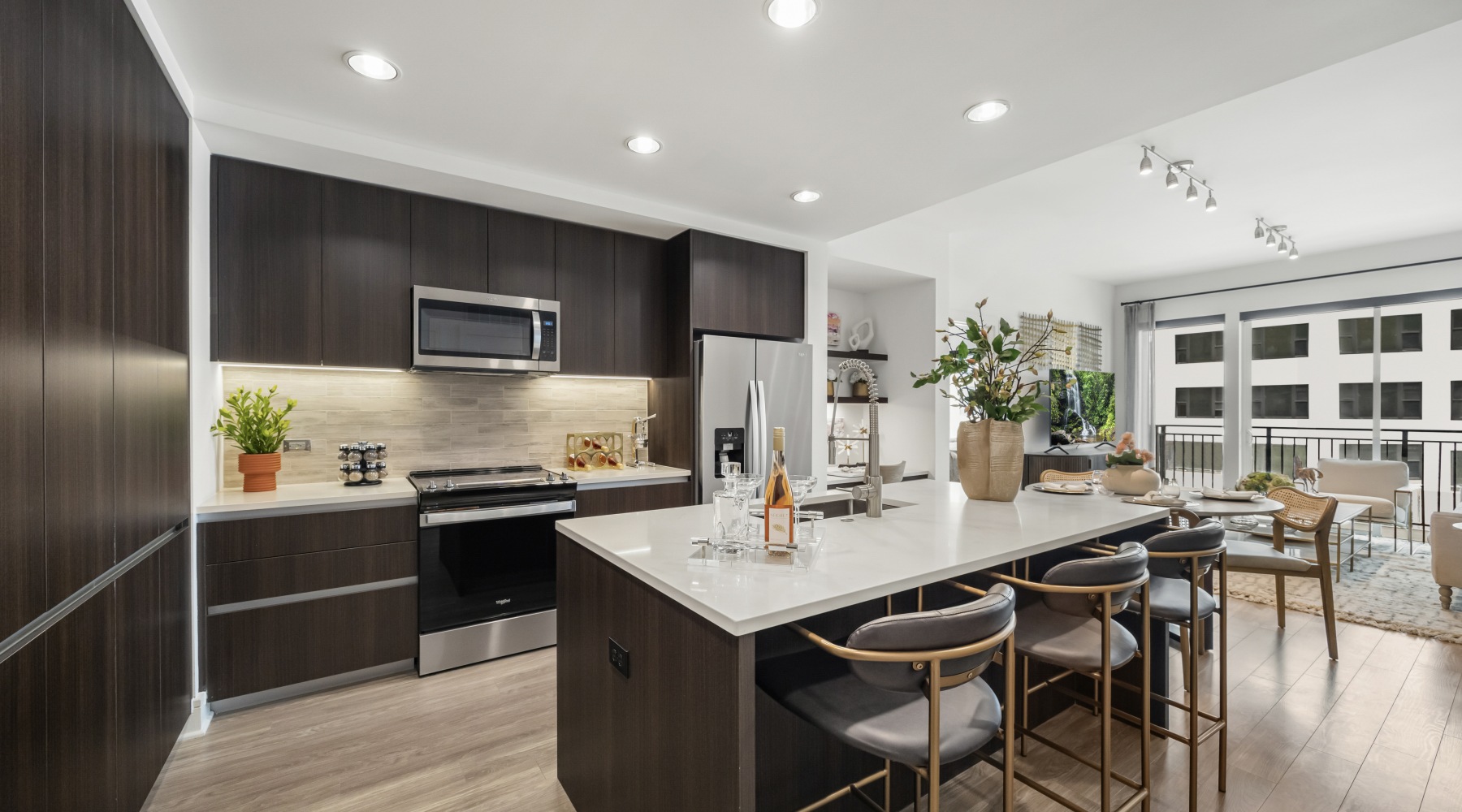 Spacious kitchens with everything you need kitchen photo with white countertops, dark wood cabinets, neutral wood flooring, and counter height island with stools