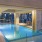 Photo of our rooftop pool with the skyline in the back. The pool has four in lounge chairs and an arbor structure above